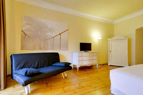 a bedroom with a couch and a bed and a dresser at Al Cavour 34 in Trento