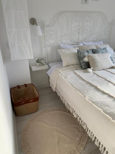 a white bedroom with a bed with a white headboard at Vikendica Fruška lipa in Čortanovci