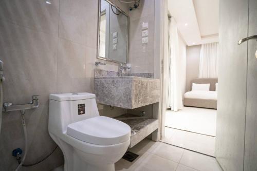 a bathroom with a white toilet and a sink at 005 - Saudi - Elegant apartment in Riyadh (Noor) in Al Hofuf