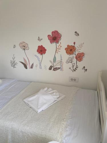 a bedroom with a bed with flowers on the wall at Vikendica Fruška lipa in Čortanovci