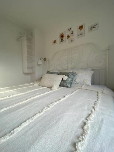 a large white bed in a white bedroom at Vikendica Fruška lipa in Čortanovci