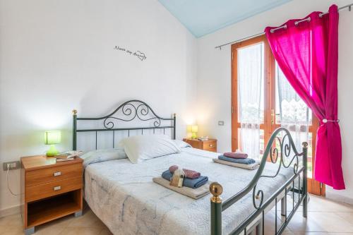 a bedroom with a bed and a dresser and a window at Villa Leonardo Sud Sardegna in Chia
