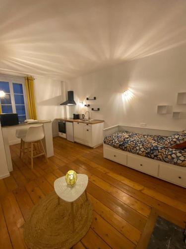 une chambre avec un lit et une table et une cuisine dans l'établissement L'Imprimerie B2, studio cosy au coeur La Roche, à La Roche-sur-Yon