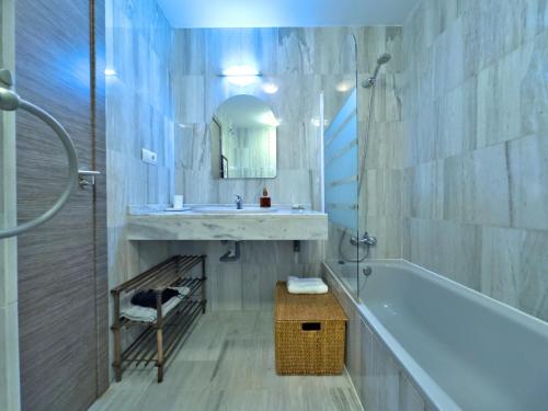 a bathroom with a sink and a tub and a mirror at Apartamento en zona Cabopino in Marbella