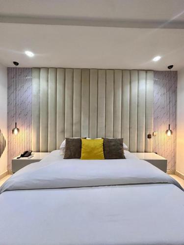 a bedroom with a large white bed with yellow pillows at Cozy one bedroom apartment in Abuja