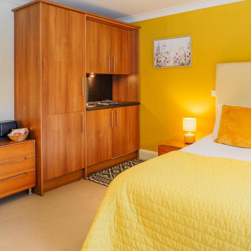 a bedroom with a bed and a cupboard at Bagshaw Lodge in Bakewell