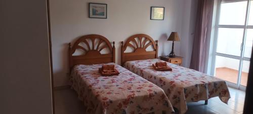 Un dormitorio con dos camas y una ventana. en T1 em Alvor, en Alvor