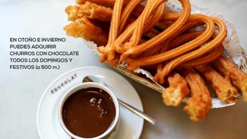a plate of food with fries and a cup of sauce at Ático con vistas a la ciudad in Ontinyent