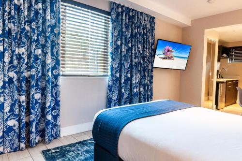 a bedroom with a bed and a window with blue curtains at Waterside Hotel and Suites in Miami Beach