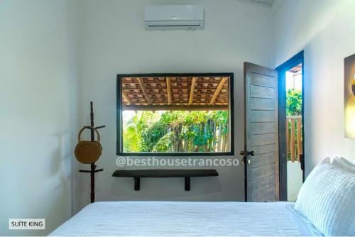 a bedroom with a bed and a window at Best House Trancoso in Porto Seguro