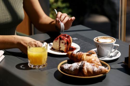a table with a plate of cake and coffee and pastries at La Rotta Rooms in Agrigento