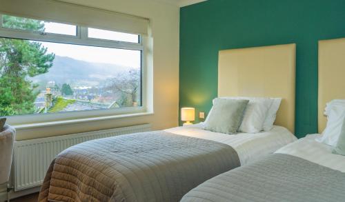 a bedroom with two beds and a window at Bagshaw Lodge in Bakewell