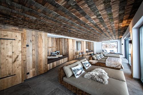 a living room with wooden walls and couches at Brunnenhof Oberstdorf - Ferienwohnungen mit Hotel Service in Oberstdorf