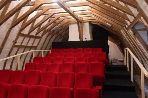 un auditorium avec des chaises rouges et un escalier dans l'établissement Château des Archevêques avec parc dans un village, à Artannes-sur-Indre