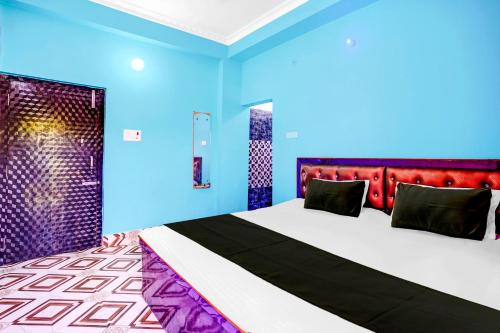a bedroom with a large bed and blue walls at Hotel O OM PALACE & BANQUET HALL in Deoghar