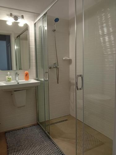 a bathroom with a glass shower and a sink at Safirului apartment in Bragadiru