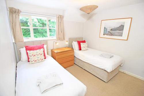 a bedroom with two beds and a window at Green Cottage in Porthmadog