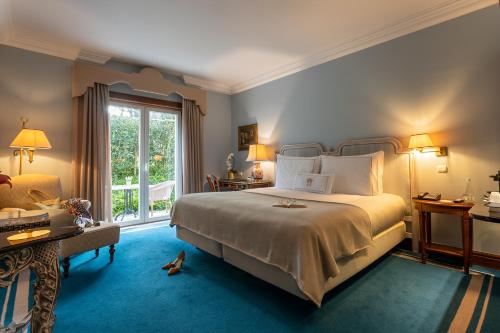里斯本Pestana Palace Lisboa Hotel & National Monument - The Leading Hotels of the World的带一张大床和一扇窗户的卧室