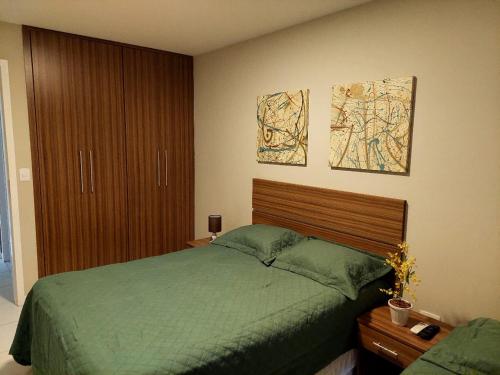 カボ・フリオにあるMandai Flat Hotelのベッドルーム1室(緑色のベッド1台、木製ヘッドボード付)