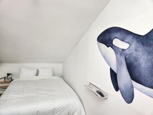 een slaapkamer met een gevulde walvis aan de muur bij Studio downtown, proche ville close, Wifi in Concarneau