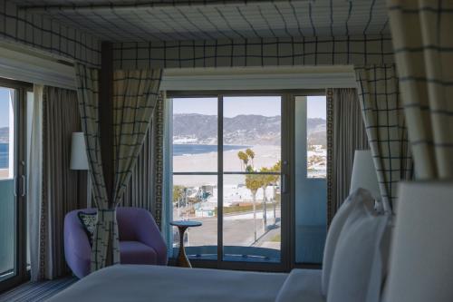 a hotel room with a bed and a view of the ocean at Regent Santa Monica Beach in Los Angeles