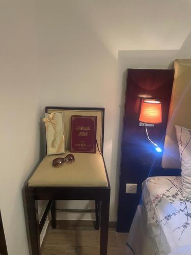 a bedroom with a table with a book and glasses on it at Elegant private room with attached bathroom in Al Muwayqi‘ī