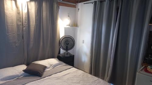 福塔莱萨Meu Canto hospedagem的带床和风扇的卧室