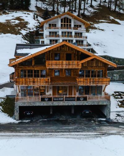 a large wooden house in the snow at Samnaun, ChaletdMot in Samnaun