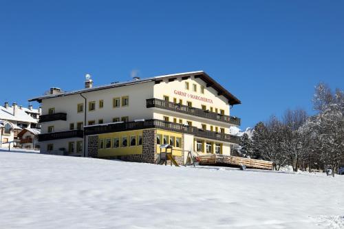a hotel in the snow on a snowy hill at GARNI' Margherita in Predazzo
