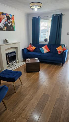 a living room with a blue couch and a fireplace at Florence house in Thornaby on Tees