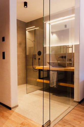 a glass shower in a room with a desk at Samnaun, ChaletdMot in Samnaun