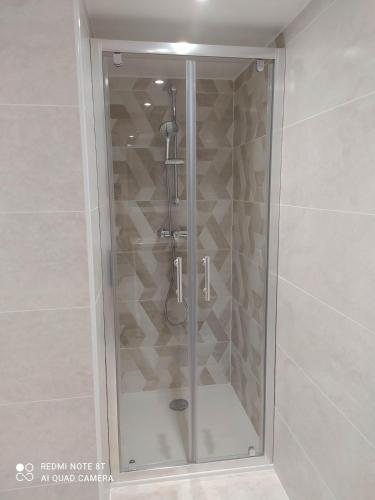 une douche avec une porte vitrée dans une salle de bain dans l'établissement Studio entrée indépendante idéal vacance ou travail, à Istres