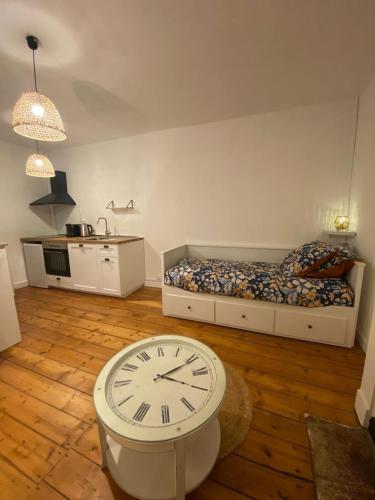- une chambre avec un lit et une horloge à l'étage dans l'établissement L'Imprimerie C2, studio cosy au coeur La Roche, à La Roche-sur-Yon