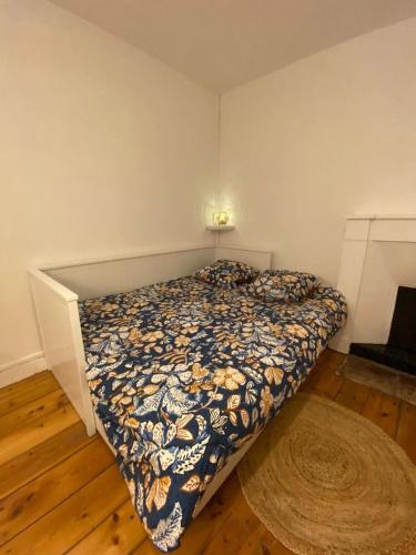 une chambre avec un lit avec une couette dessus dans l'établissement L'Imprimerie C2, studio cosy au coeur La Roche, à La Roche-sur-Yon