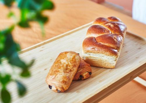 una tabla de cortar de madera con pan y repostería en Bali Room - Romantic Escape, en Haubourdin