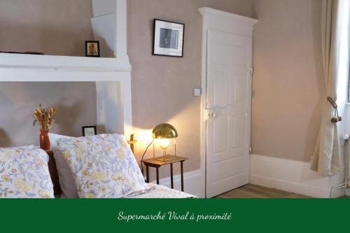 a bedroom with a bed and a table with a lamp at La Verrière - Chambre d'hôtes et gîte de charme in Poligny