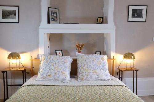 a bedroom with a bed with two pillows and two lamps at La Verrière - Chambre d'hôtes et gîte de charme in Poligny