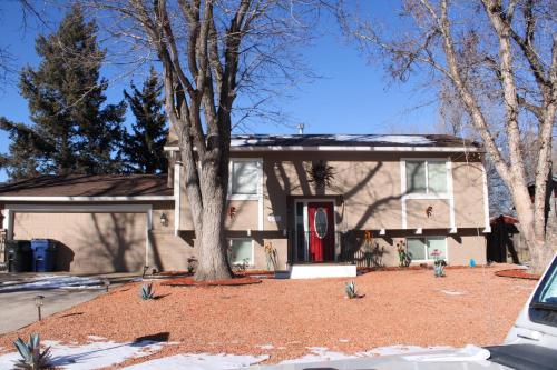 a house with a tree in front of it at Colorado Four Season Funhouse in Colorado Springs