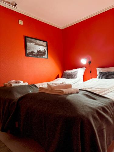 two beds in a room with red walls at Finnholmen Brygge in Henningsvær