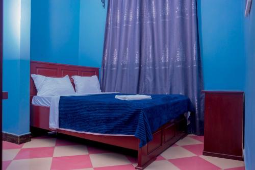 a bedroom with a bed with blue and purple walls at Lasts minute lodge in Boma la Ngombe