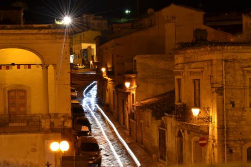 a city street at night with cars parked at Villa Adriana B&B in Comiso