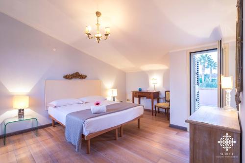 ein Schlafzimmer mit einem großen Bett und einem Tisch in der Unterkunft Villa Festosa - Luxury retreat by the beach in Villaggio Azzurro