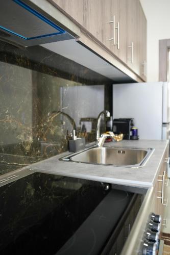 a kitchen with a sink and a microwave at Nastas-Home in Igoumenitsa