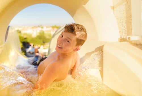 a young boy sitting in a water slide at Arizona Grand Resort in Phoenix