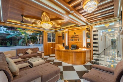a lobby with couches and a bar in a building at Cochin Airport Hotel in Ernakulam