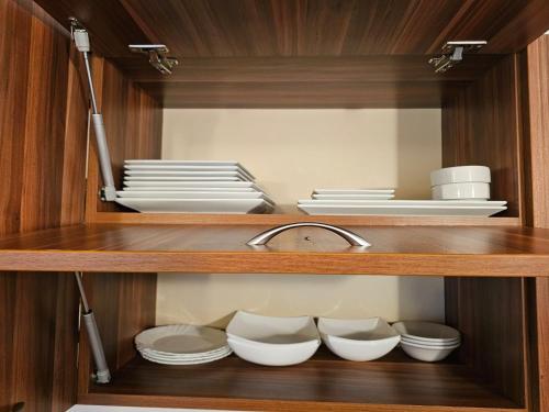a cupboard with plates and bowls and a sink at Емили Фемили Хаус in Koprivshtitsa