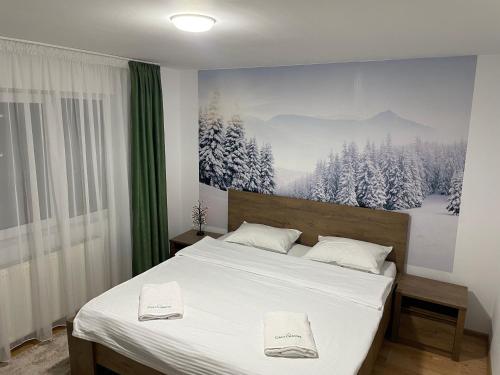 a bedroom with a bed with two white towels on it at Casa Ceteras in Cavnic