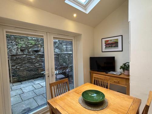 a dining room with a table with a green bowl on it at Rothay Cottage in Ambleside