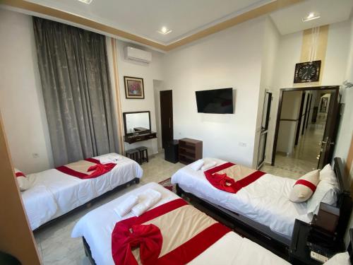 a hotel room with three beds with red bows at Hotel Biarritz in Tangier