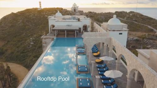a pool with chairs and umbrellas at a hotel at 4BD Oceanfront Unit Vista Encantada - Cabo in Cabo San Lucas